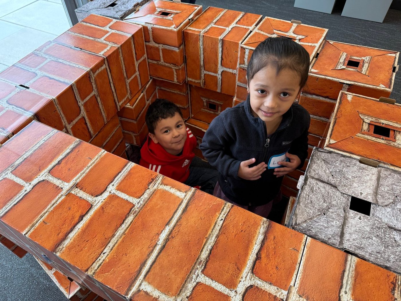 Two children inside the fort they built from giant blocks